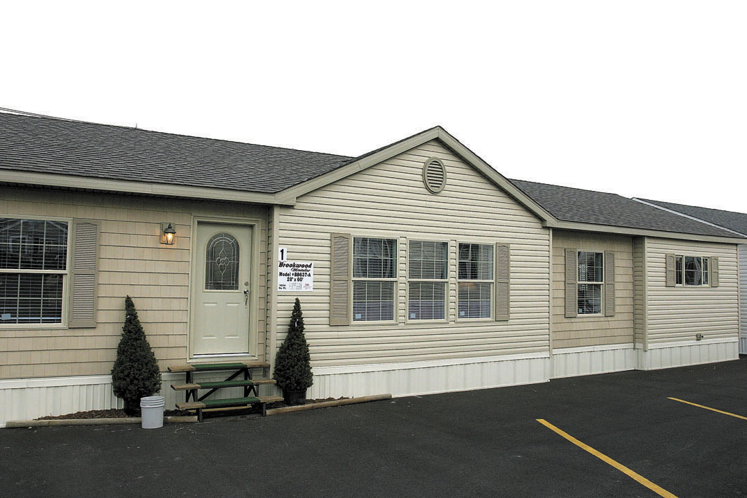 Manufactured home with light siding, a front gable and large windows